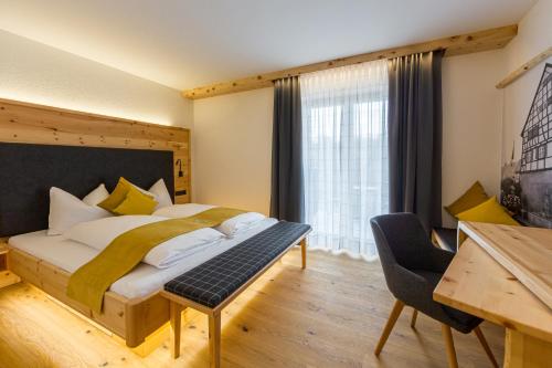 sypialnia z łóżkiem, biurkiem i oknem w obiekcie Gästehaus Sonnenwirth w mieście Heilbronn