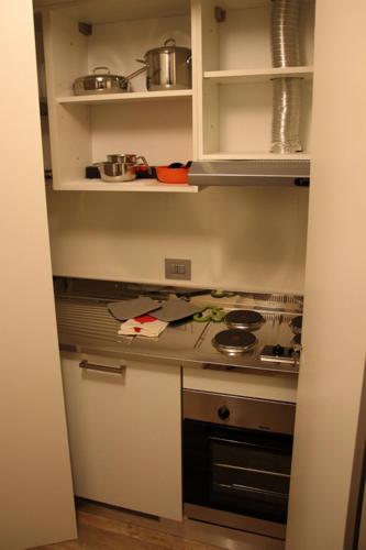a small kitchen with a stove and cabinets at Amalia Bakery Home in Gallarate
