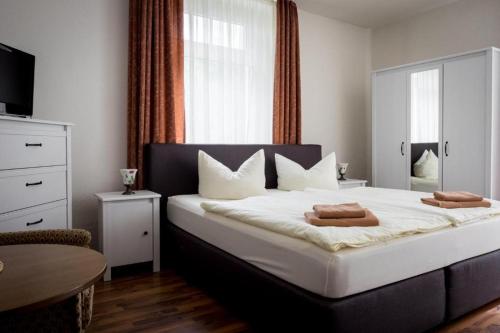 um quarto com uma cama grande com duas toalhas em Villa Angelika em Dresden