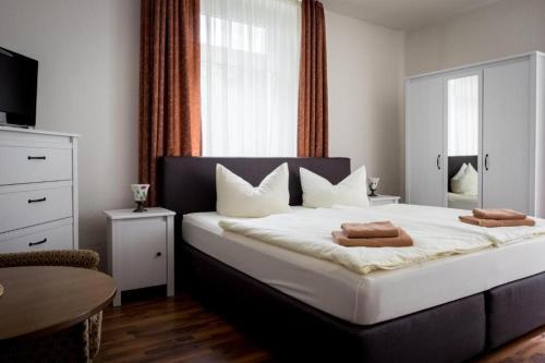 - une chambre avec un grand lit et 2 serviettes dans l'établissement Villa Angelika, à Dresde