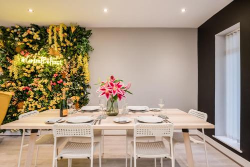 a dining room with a large wall of flowers at Central Belfast Apartments: Citygate in Belfast