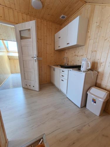 a kitchen with a white refrigerator and a sink at Maja in Łeba