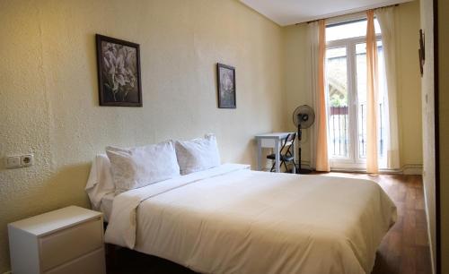 a bedroom with a white bed and a window at Apain HT in San Sebastián