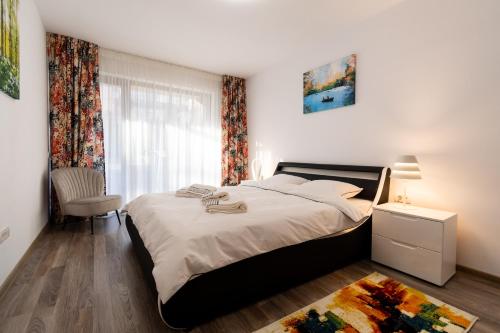 a bedroom with a large bed and a window at Transylvanian Apt. w/ lrg. terrace and parking - KarpatenHaus in Braşov