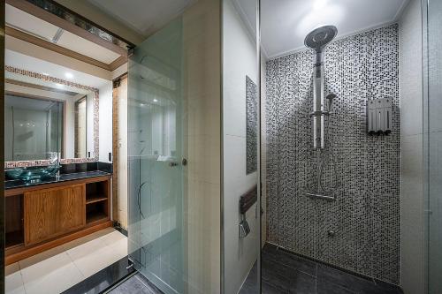 a bathroom with a glass shower and a sink at Hotel Cullinan Yongin in Yongin