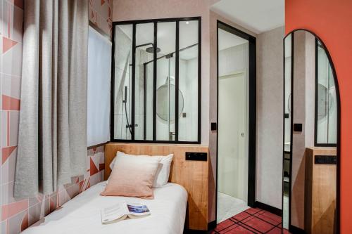 a small bedroom with a bed and a mirror at Republik Hotel in Lyon