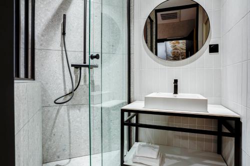 a bathroom with a shower with a sink and a mirror at Republik Hotel in Lyon