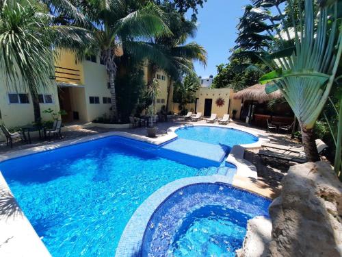 a swimming pool in a backyard with palm trees at Hotel LunaSol in Playa del Carmen