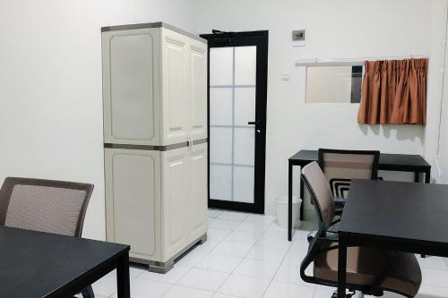 a kitchen with a refrigerator and a table and chairs at Social Hub by TwoSpaces in Jakarta