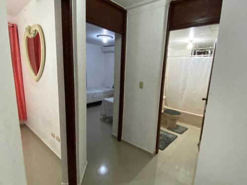 a hallway with a door to a bathroom with a toilet at 1Dom Rep - Huge cozy 3 bedrooms - close to all transportation Jacobo Majluta - Residencial Paradise V Colina Arroyo 1 in Santo Domingo