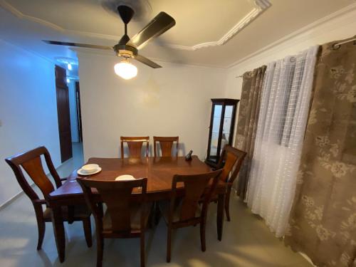 a dining room table with chairs and a ceiling fan at 1Dom Rep - Huge cozy 3 bedrooms - close to all transportation Jacobo Majluta - Residencial Paradise V Colina Arroyo 1 in Santo Domingo