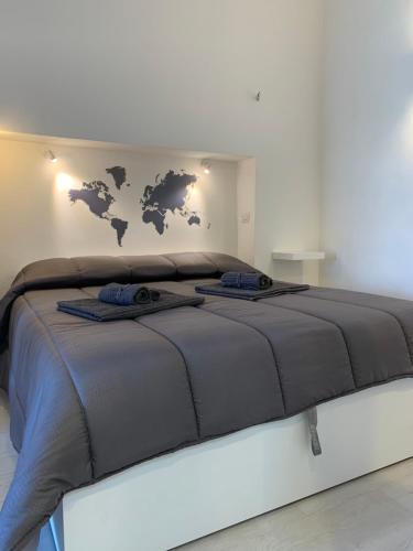 un grande letto grigio con una mappa del mondo sul muro di Bed and Beach a Messina