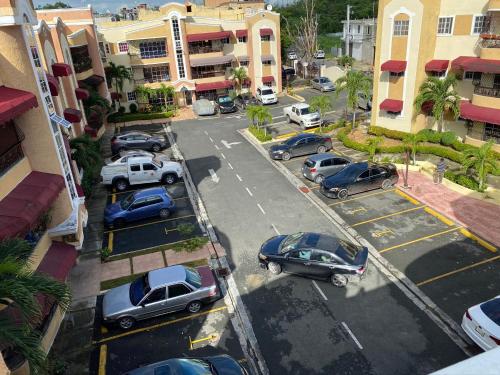 an aerial view of cars parked in a parking lot at 1Dom Rep - Huge cozy 3 bedrooms - close to all transportation Jacobo Majluta - Residencial Paradise V Colina Arroyo 1 in Santo Domingo