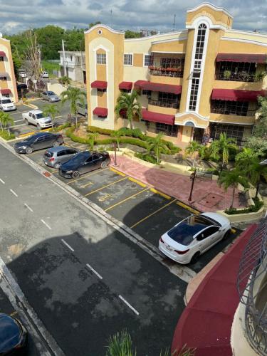 a parking lot with cars parked in front of a building at 1Dom Rep - Huge cozy 3 bedrooms - close to all transportation Jacobo Majluta - Residencial Paradise V Colina Arroyo 1 in Santo Domingo