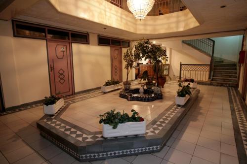 a lobby of a building with potted plants at Hotel Ichbilia فندق اشبيلية in Marrakech