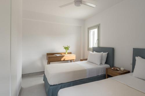 a bedroom with two beds and a desk and a window at Nevermind vacations villaB in Kastrianí