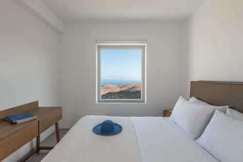 a bedroom with a bed with a blue hat on it at Nevermind vacations villaB in Kastrianí