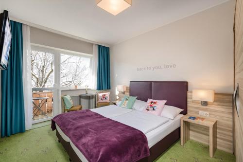 a bedroom with a large bed and a window at Hotel Blü Gastein in Bad Hofgastein