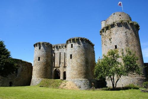 a castle with two towers on top of a field at Résidence CoatArmor in Tonquédec