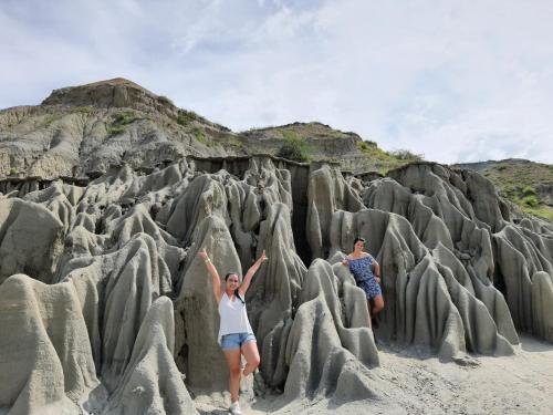 a man and a woman standing in rock formations on a beach at Tatacoa Star Eco Hotel in Villavieja