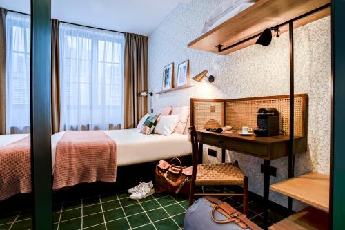 リヨンにあるレプブリーク ホテルのベッドとデスクが備わるホテルルームです。