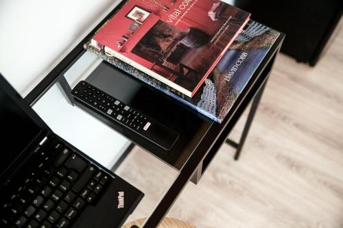 a glass table with a laptop computer and a book at Spazio 77 - The House Of Travelers in Como