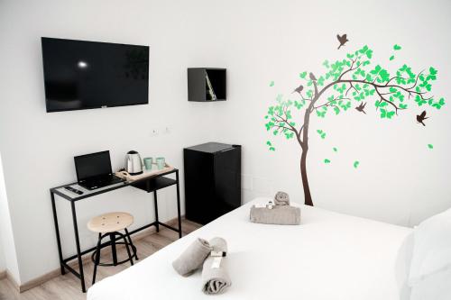 a bedroom with a bed with a tree on the wall at Spazio 77 - The House Of Travelers in Como