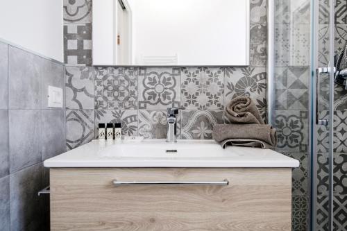 a bathroom with a sink and a mirror at Spazio 77 - The House Of Travelers in Como