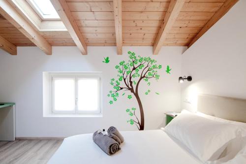 a bedroom with a tree stenciled on the wall at Spazio 77 - The House Of Travelers in Como