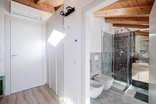 a white bathroom with a shower and a toilet at Spazio 77 - The House Of Travelers in Como