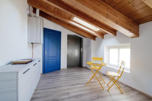a kitchen with a blue door and a table and chairs at Spazio 77 - The House Of Travelers in Como