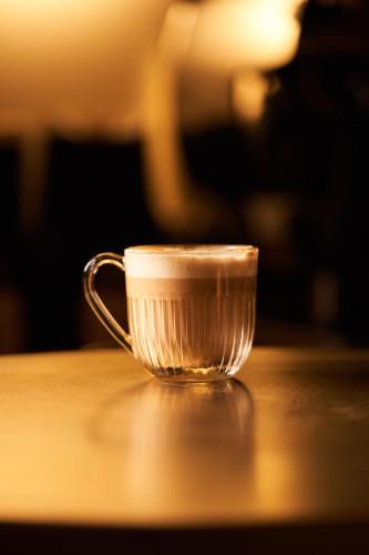 a cup of coffee sitting on a table at Hôtel du Sentier in Paris