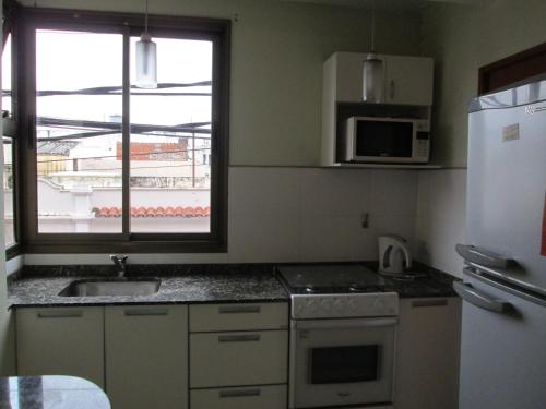 a small kitchen with a sink and a refrigerator at Aires del Parque in Salta