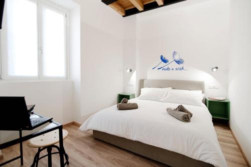 a white bedroom with a bed and a desk at Spazio 77 - The House Of Travelers in Como