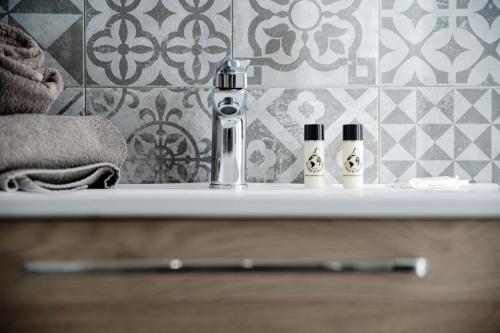 a bathroom sink with two soap bottles on it at Spazio 77 - The House Of Travelers in Como