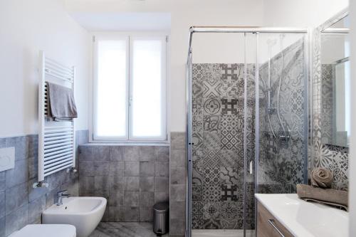 a bathroom with a shower and a toilet and a sink at Spazio 77 - The House Of Travelers in Como