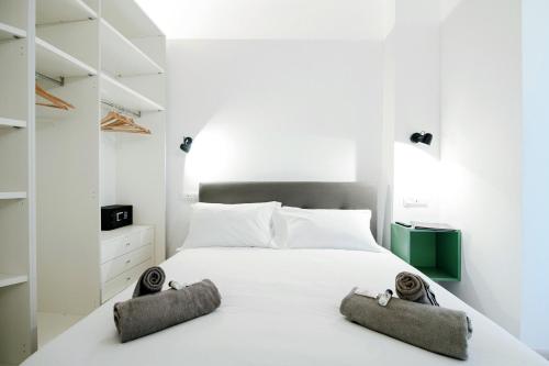 a bedroom with a white bed with two towels on it at Spazio 77 - The House Of Travelers in Como
