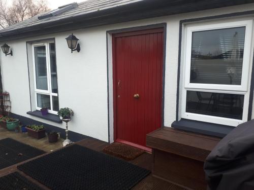 una puerta roja en una casa blanca con ventanas en Ideal one bedroom appartment in Naas Oo Kildare, en Naas