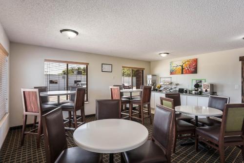 ein Restaurant mit Tischen und Stühlen und eine Küche in der Unterkunft Rodeway Inn Cedar Rapids in Cedar Rapids