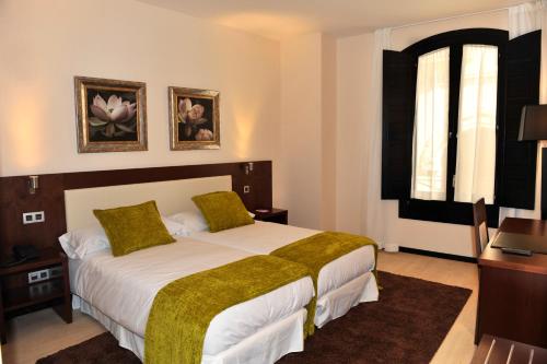 a bedroom with a large bed and a window at Hotel Don Felipe in Segovia