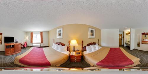a hotel room with two beds in a room at Rodeway Inn Cedar Rapids in Cedar Rapids