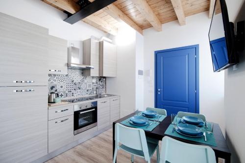 a kitchen with a table and chairs and a blue door at Spazio 77 - The House Of Travelers in Como