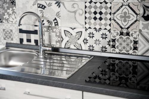a stainless steel sink in a kitchen with tiles at Spazio 77 - The House Of Travelers in Como