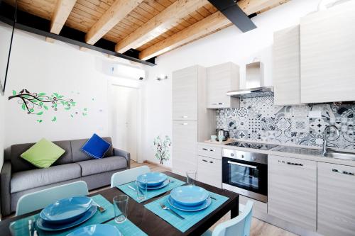 a kitchen and living room with a table and chairs at Spazio 77 - The House Of Travelers in Como