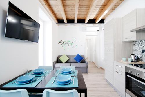 a kitchen and living room with a table and chairs at Spazio 77 - The House Of Travelers in Como
