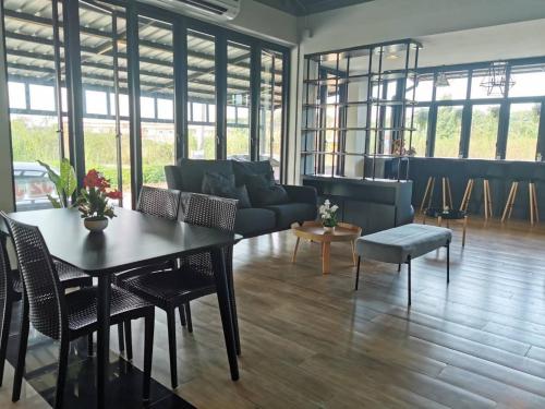 a living room with a couch and a table and chairs at J2 Residence Chiang Rai in Chiang Rai