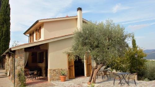 une maison avec une table et un arbre dans l'établissement Casa Vista della Roccia, à Volterra