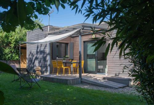 une petite maison avec une table et des chaises dans la cour dans l'établissement L'Eden Weiss, à Magny-les-Hameaux