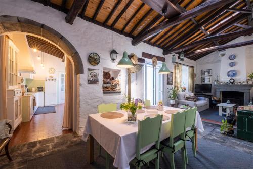 a dining room with a table and green chairs at Casa Tradicional da Vila in Vila Franca do Campo