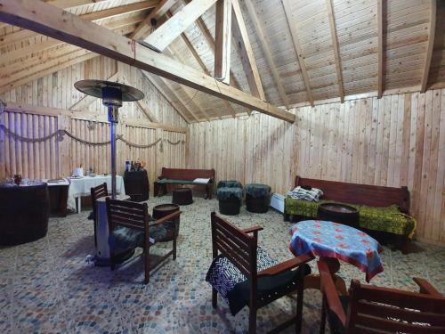 Cette chambre dispose de murs en bois, de chaises et d'une table. dans l'établissement Casa Jeni, à Humuleşti